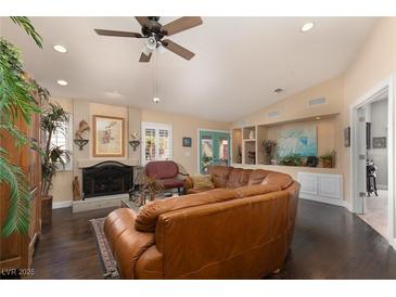 Spacious living room featuring a large leather sectional sofa and a cozy fireplace at 7200 Big Rock Cir, Las Vegas, NV 89129