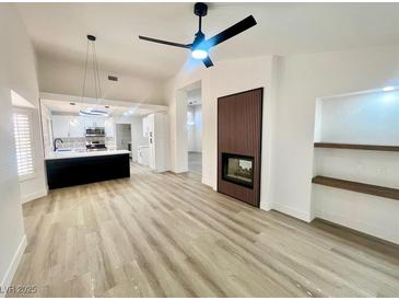 Bright living room features a fireplace, fan, and open floor plan with luxury vinyl plank flooring at 9437 January Dr, Las Vegas, NV 89134