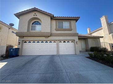 Two-story home featuring a beige stucco exterior, a two-car garage, and a well-maintained front yard at 9543 Antelope Bend Ct, Las Vegas, NV 89148