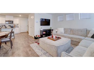Bright, open-concept living room with modern furnishings and a large sectional couch at 1132 Ruby Sparrow St, Henderson, NV 89011