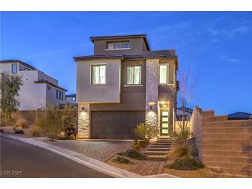 Striking two-story home with stone accents, well-lit entrance, and a neatly paved driveway at 11832 Dragontail Peak Ave, Las Vegas, NV 89138