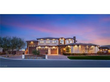 Elegant stucco home with a three-car garage and manicured landscaping at sunset at 5764 Aspen Falls Cir, Las Vegas, NV 89149