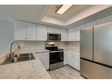Updated kitchen features stainless steel appliances, white cabinets, and modern countertops at 6250 W Flamingo Rd # 43, Las Vegas, NV 89103