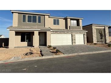 Two-story home with a two-car garage and a modern stone facade at 7142 Twilight Rider Ct, Las Vegas, NV 89118