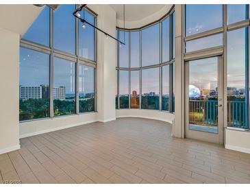 Bright living room with expansive windows offering city views and wood look tile flooring at 360 E Desert Inn Rd # 602, Las Vegas, NV 89109