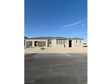 A modern one-story home with a three car garage and stucco exterior at 4630 Blushing Dawn Ave, Las Vegas, NV 89118