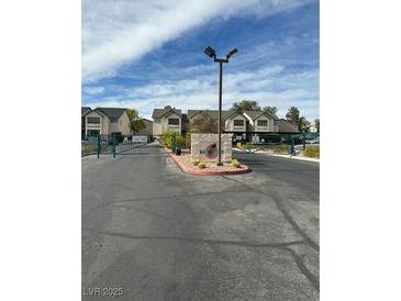 Gated community entrance with lush landscaping and modern signage at 5121 Lindell Rd # 104, Las Vegas, NV 89118