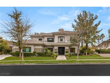 Elegant two-story home featuring manicured landscaping and a stately entrance at 632 Canyon Greens Dr, Las Vegas, NV 89144