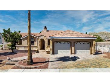 Inviting single-story home featuring a spacious two-car garage, tile roof, and charming desert landscaping at 3665 S Pointe Cir, Laughlin, NV 89029