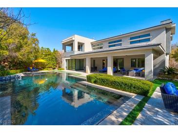 A stunning backyard pool with a modern home in the background at 43 Grey Feather Dr, Las Vegas, NV 89135