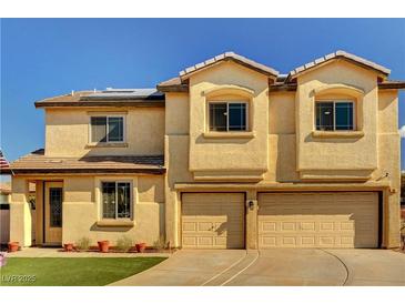 Two-story stucco home featuring a two-car garage, well-maintained lawn, and a classic desert landscape at 58 Desert Castle Ct, Henderson, NV 89012