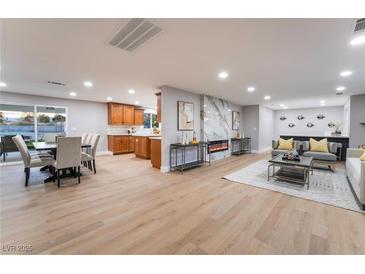 Bright, open-concept living room featuring a fireplace, light wood floors, and modern decor at 616 Lacy Ln, Las Vegas, NV 89107