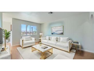 Bright living room featuring a white sofa set and modern decor accents at 1810 N Decatur Blvd # 201, Las Vegas, NV 89108