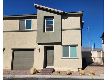 Two-story tan home with a one-car garage, neutral trim, and a brick walkway at 2734 Champagne Gold Ave, North Las Vegas, NV 89086