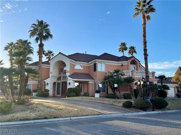 Elegant two-story home with desert landscaping, palm trees and a circular driveway at 3341 Camino Gardens Way, Las Vegas, NV 89146