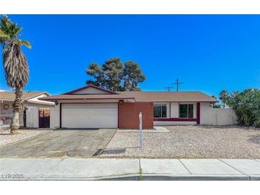 Single-story home featuring an attached two-car garage, neutral gravel landscaping, and a mature palm tree at 42 Del Amo Dr, Las Vegas, NV 89110