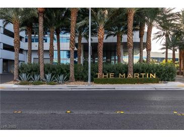 The Martin building entrance with mature palms and manicured landscaping is seen from street level at 4471 Dean Martin Dr # 1105, Las Vegas, NV 89103