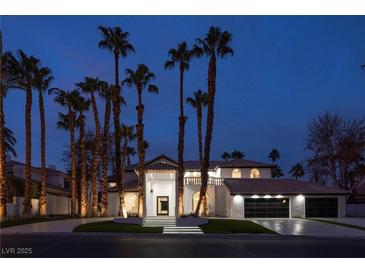 Elegant two-story home featuring a tile roof, a three-car garage, and lush landscaping with swaying palm trees at 74 Innisbrook Ave, Las Vegas, NV 89113
