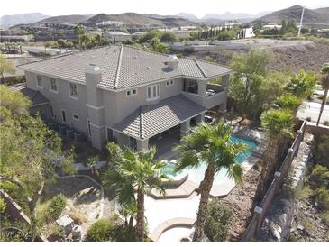 Stunning aerial view of home featuring a backyard pool and a tile roof in a desert landscape at 861 Majestic Ridge Ct, Henderson, NV 89052
