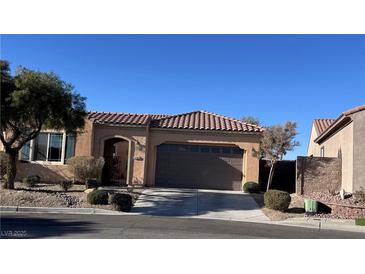 Single level home featuring a tile roof, desert landscaping, and attached two car garage at 2764 Leys Burnett Ave, Henderson, NV 89044