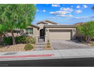 Charming single-story home with a two-car garage, neutral colors and a paved driveway and walkway at 32 Via Del Fiume, Henderson, NV 89011