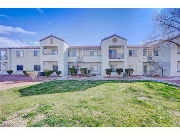 Inviting condo complex with well-maintained landscaping, external stairways, and private balconies under a bright blue sky at 3318 N Decatur Blvd # 1020, Las Vegas, NV 89130