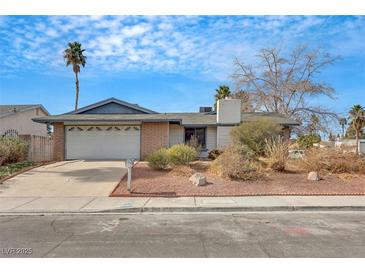 Charming single-story home featuring an attached two-car garage and mature landscaping at 700 Northstar St, Las Vegas, NV 89107