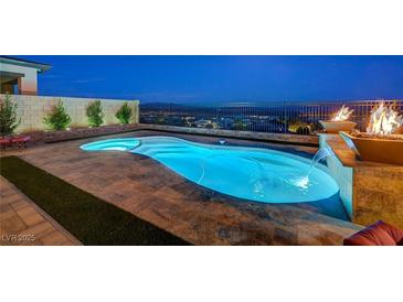 Enjoy this amazing pool with waterfall features and an elegant fire display overlooking the city lights at 8 Reverie Heights Ave, Henderson, NV 89011