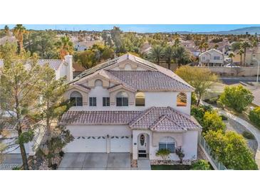 Charming two-story home featuring a three-car garage, arched windows, and a well-manicured front yard at 2107 Eaglepath Cir, Henderson, NV 89074