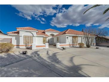 Charming single-story home with a red tile roof, circular driveway, and stucco exterior at 519 Cayuga Ct, Boulder City, NV 89005