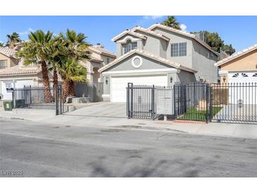 Two-story home with gray stucco, tile roof, black wrought iron gate, and palm trees at 5264 Silverheart Ave, Las Vegas, NV 89142