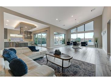 Open-concept living room boasts hardwood floors, modern decor, and seamless access to the outdoors at 6832 Apogee Ridge Ct, Las Vegas, NV 89135