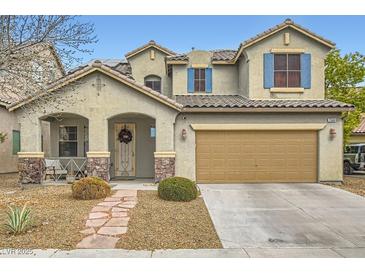 Two-story home with a two-car garage, stone accents, drought landscaping, and a covered porch at 7344 Jelson Falls St, Las Vegas, NV 89131