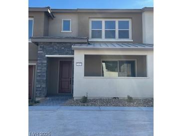 Two-story home featuring a stone facade, a covered entryway, and neutral color palette at 11414 Ethereal Landing Ave, Las Vegas, NV 89138