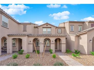 Inviting townhome exterior with desert landscaping, covered porch, and neutral color palette at 2607 Aversa St, Henderson, NV 89044