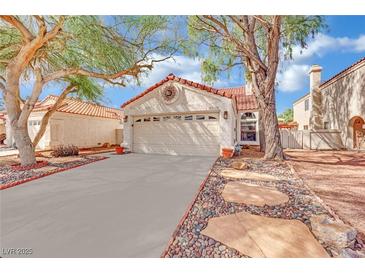 Charming home featuring a two-car garage, red tile roof, and desert landscaping at 3916 Rhine Way, Las Vegas, NV 89108