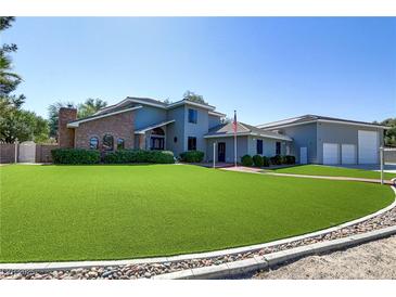 Two-story home with a well-maintained front lawn and a brick chimney on the left side of the building at 4075 E Oquendo Rd, Las Vegas, NV 89120