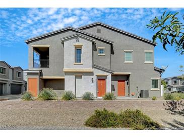 Contemporary two-story home with a gray exterior, orange doors, and low maintenance desert landscaping at 4566 Ganier Ct # 1125, North Las Vegas, NV 89031