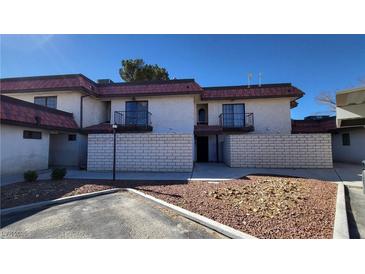 Two-story townhome featuring balconies, brick facade, and manicured front yard at 701 Bourbon St # G3, Pahrump, NV 89048