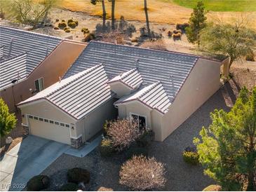 A view of the home's roof, garage, driveway and tidy landscaping and lawn at 7505 Chaffinch St, North Las Vegas, NV 89084