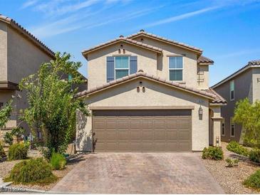 Two-story home featuring a neutral color scheme and a two-car garage, complemented by a well-maintained front yard at 9734 Cluny Ave, Las Vegas, NV 89178