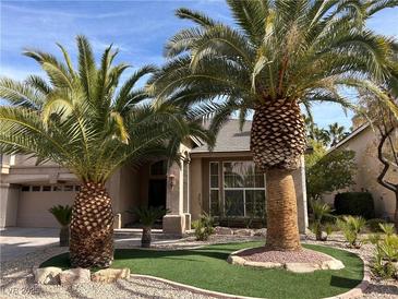 Well-maintained front yard with desert landscaping and decorative palm trees create curb appeal at 11118 Scotscraig Ct, Las Vegas, NV 89141