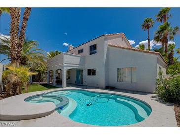 Beautiful backyard pool with mature palm trees and sunny skies at 2010 Spruce Brook Dr, Henderson, NV 89074