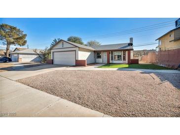 Home featuring a two-car garage, wide driveway, and manicured front yard at 5871 Mescal Way, Las Vegas, NV 89110