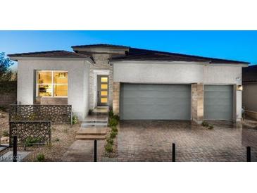 Attractive single-story home featuring a three-car garage, modern design, and low-maintenance landscaping at 8988 Indigo Rose St, Las Vegas, NV 89166