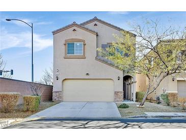 Charming two-story home featuring a tan stucco exterior, two car garage and well-maintained landscaping at 9413 Aggie Ct, Las Vegas, NV 89148