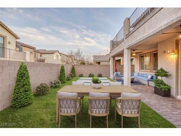 Inviting backyard with a dining table, manicured lawn, and a comfortable outdoor lounge area at 12382 Piazzo St, Las Vegas, NV 89141