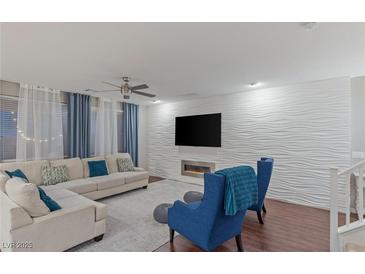 Bright living room featuring a modern fireplace, textured wall, and comfortable seating arrangement at 12382 Piazzo St, Las Vegas, NV 89141