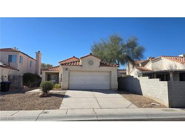 Charming one-story home with a two-car garage, a red tile roof, and a well-kept front yard at 1805 Monte Alban Dr, North Las Vegas, NV 89031