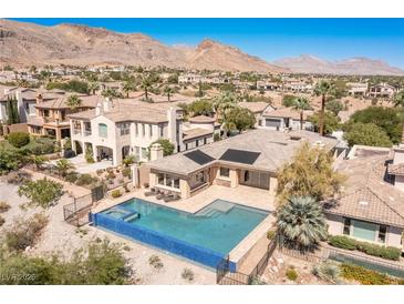 Desert home boasts an inviting pool, mountain views and lush surroundings in a desirable neighborhood at 11473 Glowing Sunset Ln, Las Vegas, NV 89135